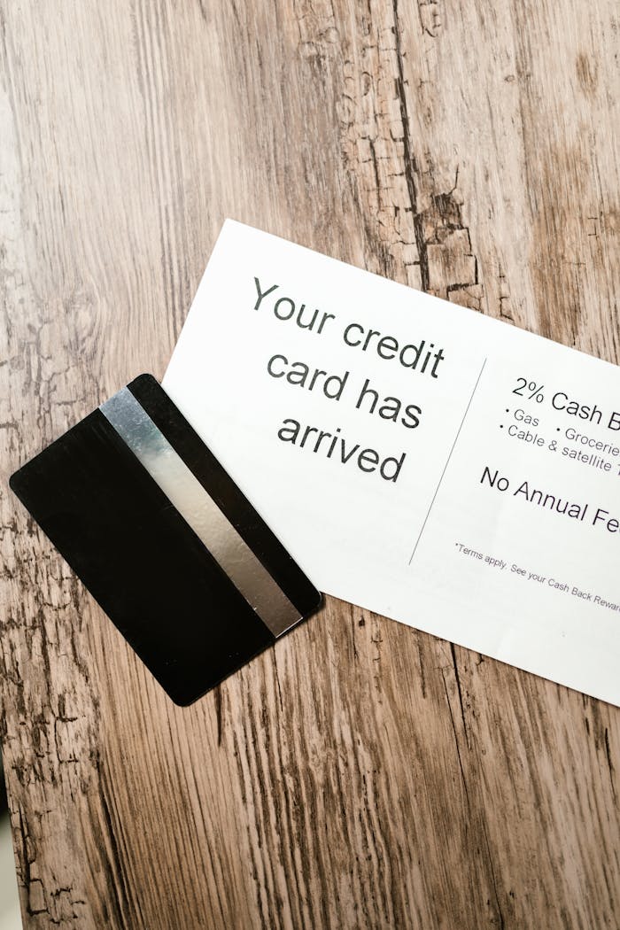 Close-up view of a credit card and welcome letter on a wooden table, emphasizing finance and banking.